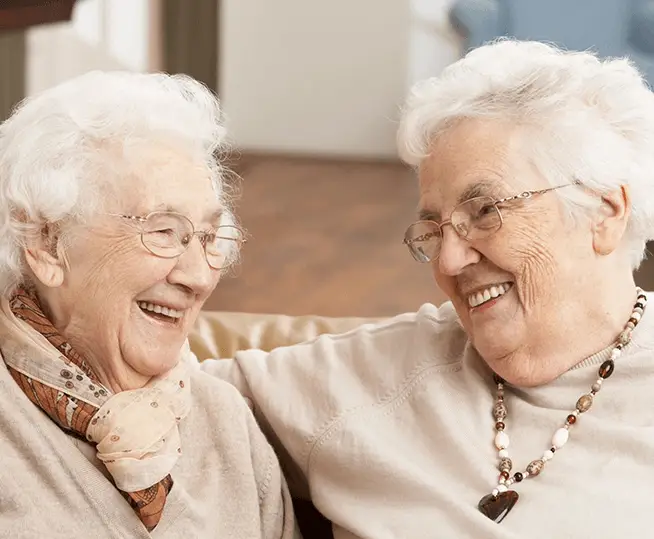 Two older women sitting next to each other.